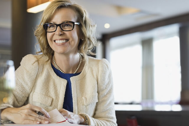 A smiling businesswoman with glasses.