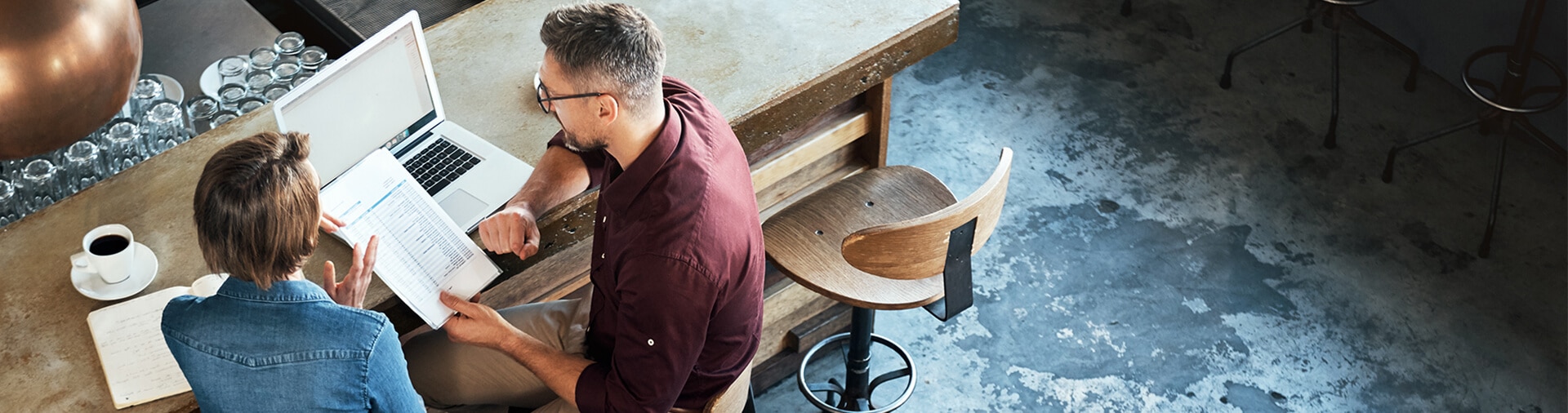 Man and woman reviewing business documents in a restaurant.