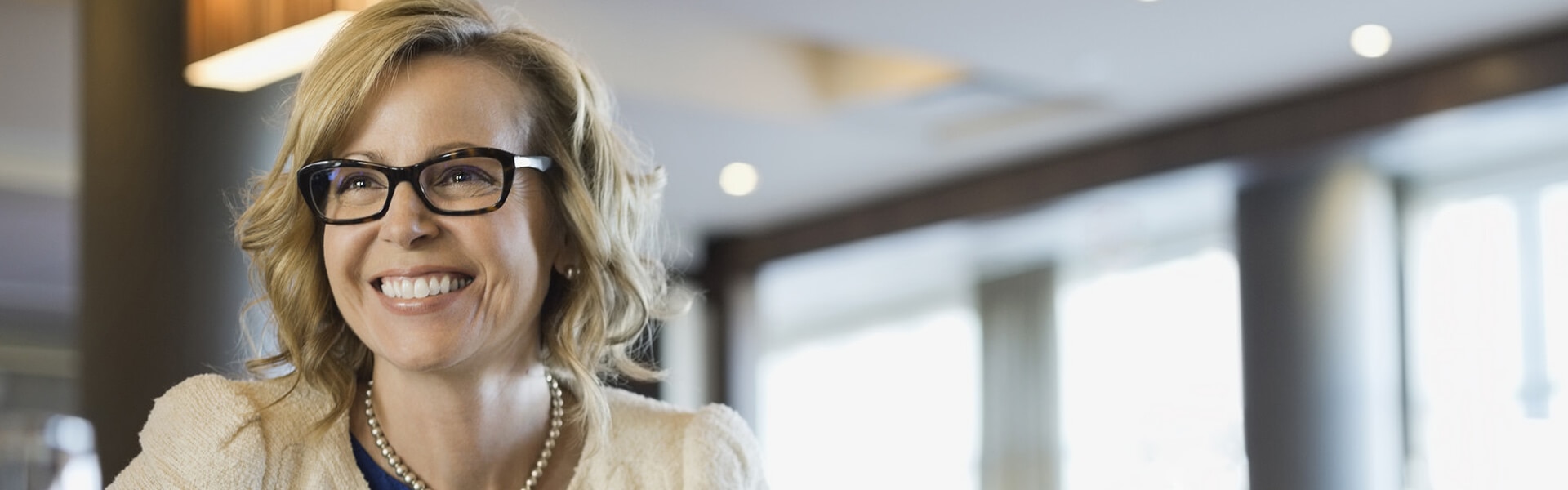 A smiling businesswoman with glasses.