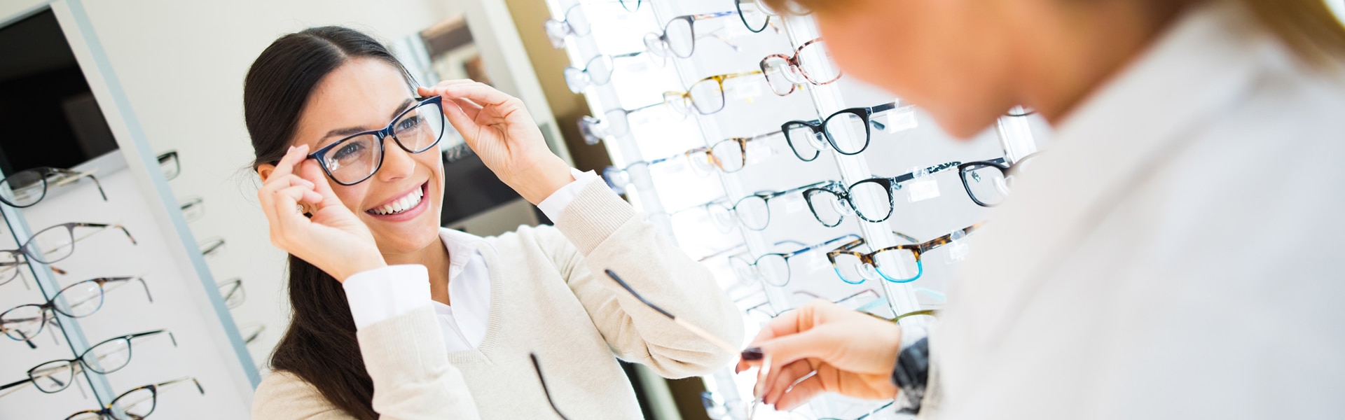 Young woman trying on glasses in an eye doctor's office.