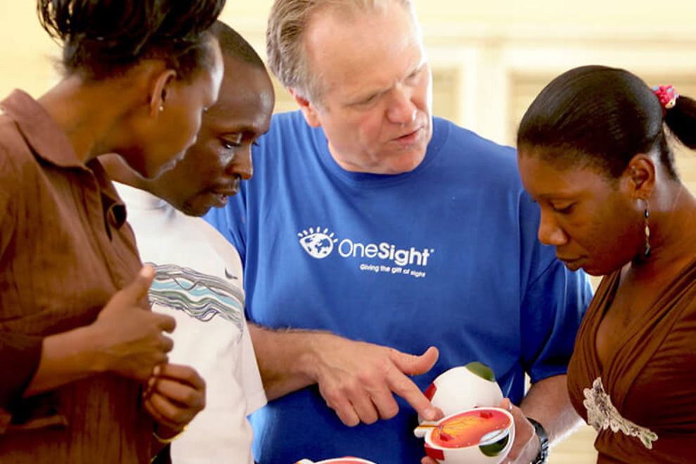 OneSight volunteer showing model of eye to a group of people 