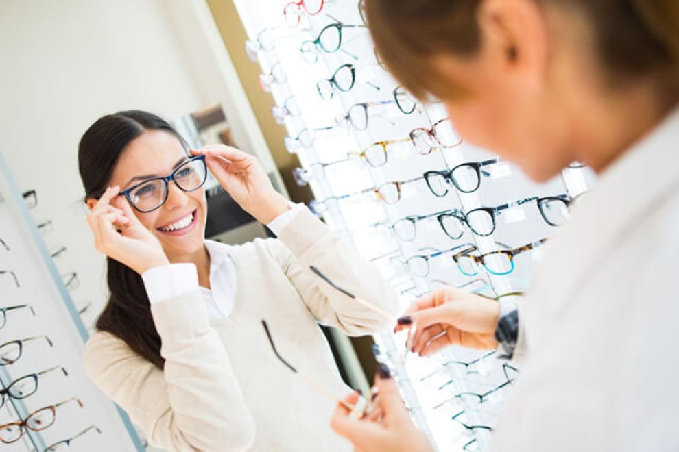 woman trying on glasses in an eye doctor's office